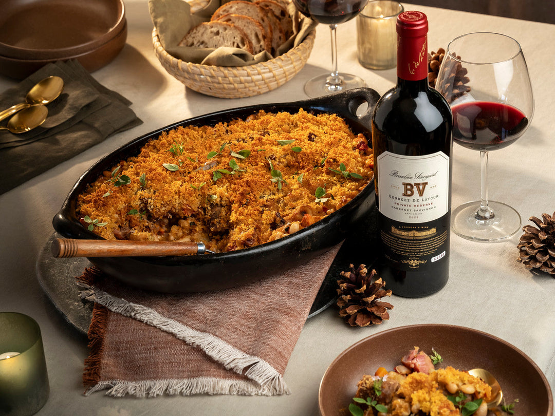 Duck and pork cassoulet on an autumn table with a bottle of Beaulieu Vineyard Georges de Latour Private Reserve Cabernet Sauvignon wine.
